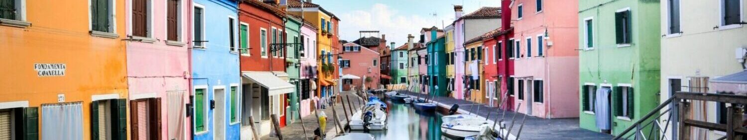 Boats on Canal between houses in Burano city Venice. Photo by Lopez Robin