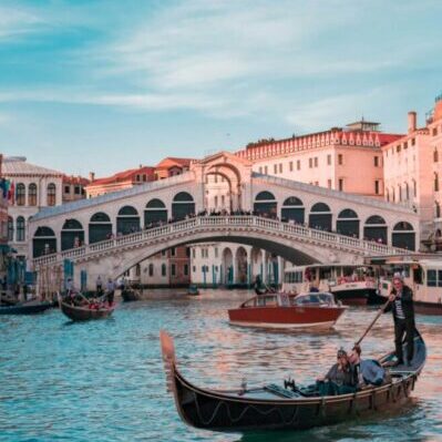 Gondolas going under Rialto Bridge, Venezia. Photo by Damiano Baschiera