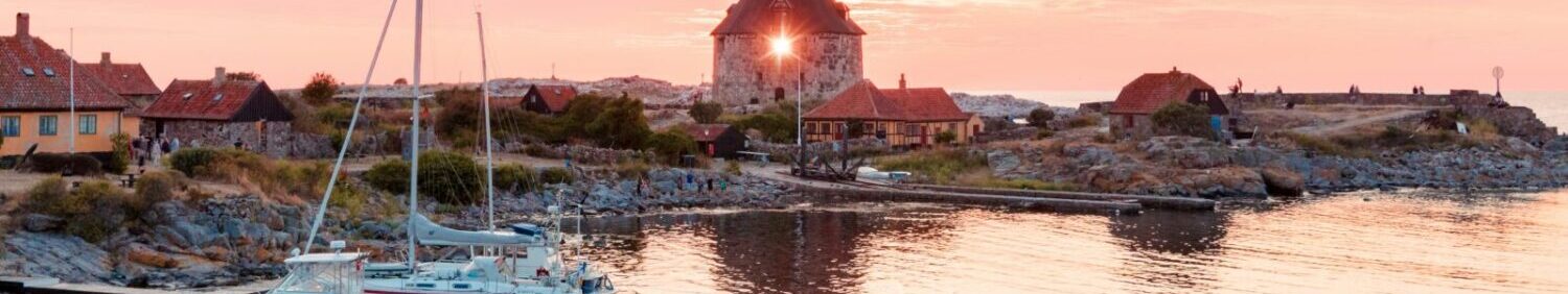 Denmark Sunset and lighthouse with fishing boats Frederiksø Gudhjem Mantas Hesthaven